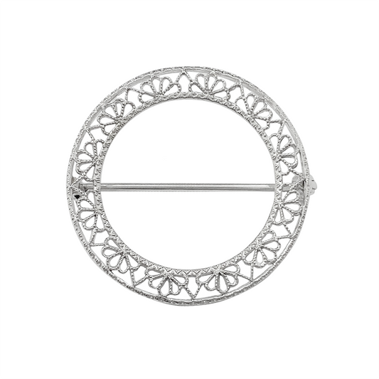 Silver filigree circle brooch on a white background.