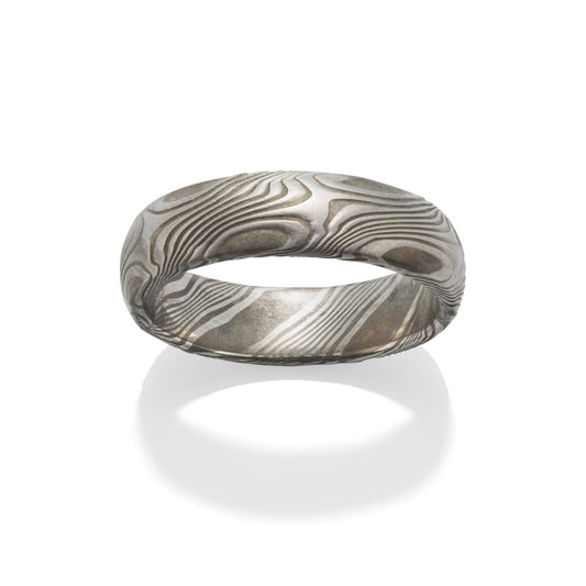 Damascus steel band ring on a white background