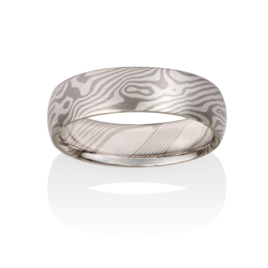 Damascus steel band ring on a white background