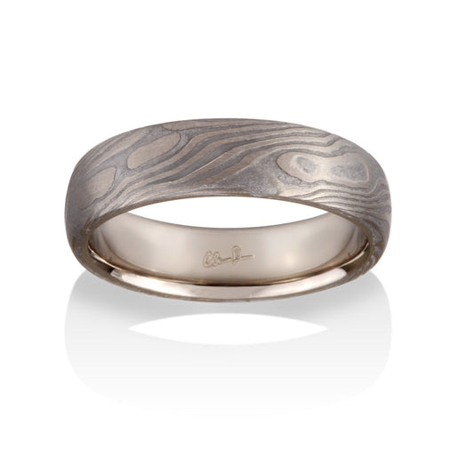 Damascus steel band ring on a white background