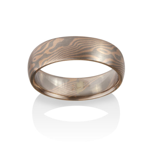 Damascus steel band ring on a white background