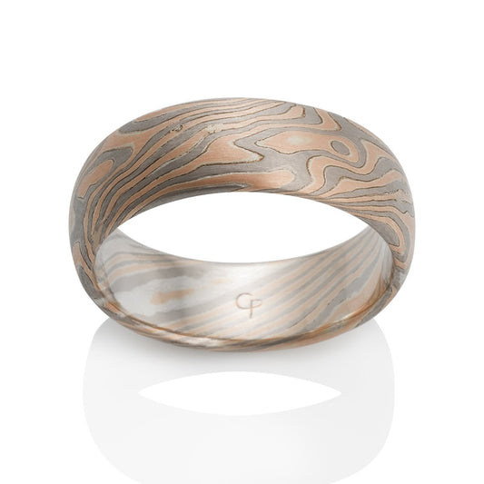 Damascus steel band ring on a white background