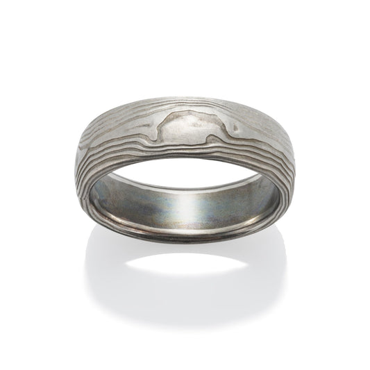 Damascus steel band ring on a white background