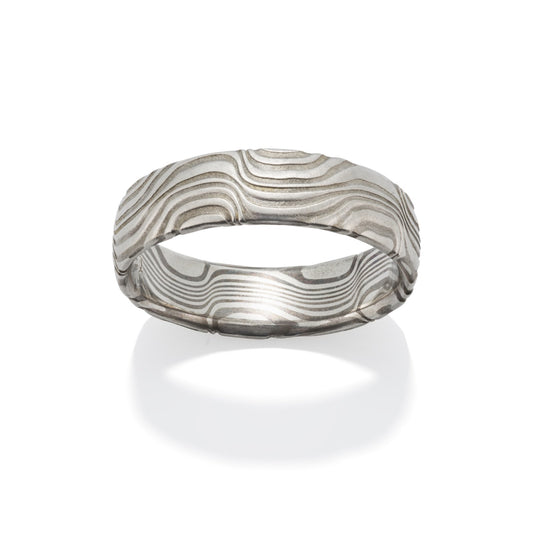 Damascus steel band ring on a white background