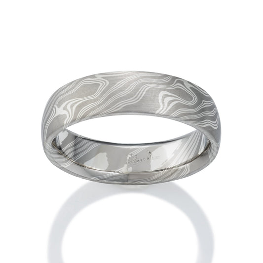 Damascus steel band ring on a white background