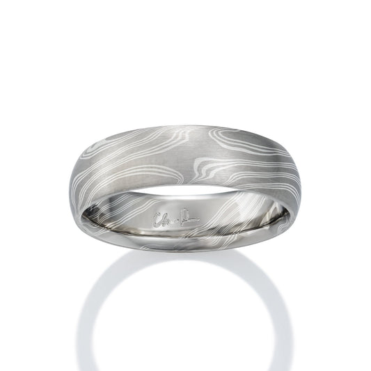 Damascus steel band ring on a white background