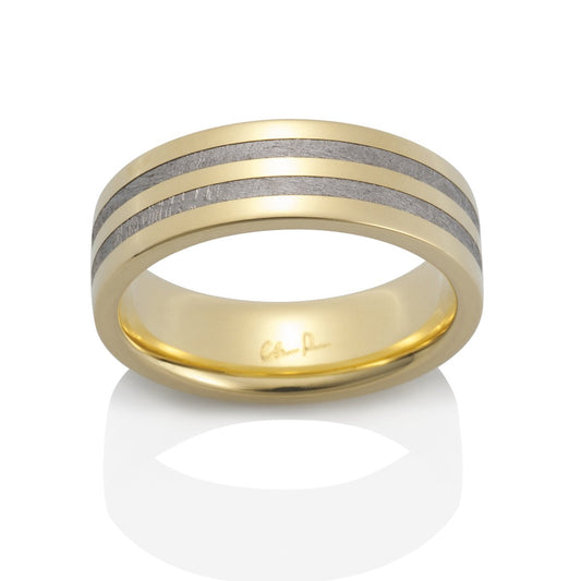 Gold ring with a meteorite inlay on a white background.