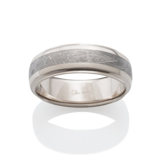 Silver ring with a meteorite inlay on a white background.