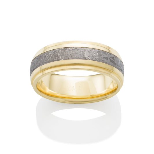 Gold ring with a meteorite inlay on a white background.