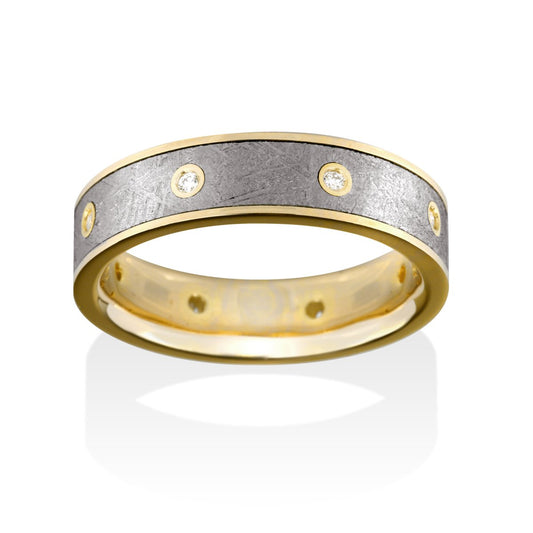 Gold ring with a meteorite inlay and diamond accents on a white background.