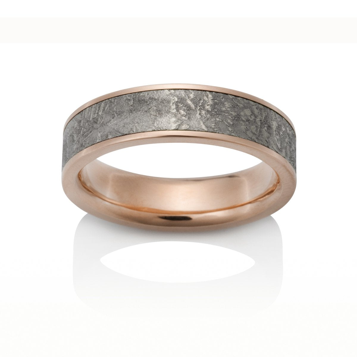 Rose gold ring with a meteorite inlay on a white background.