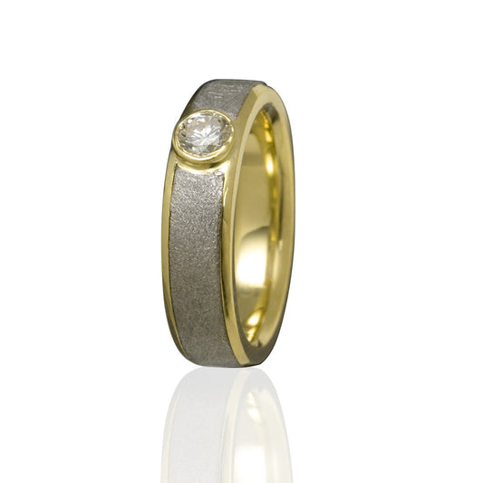 Gold ring with a round centered diamond and meteorite inlay on a white background.