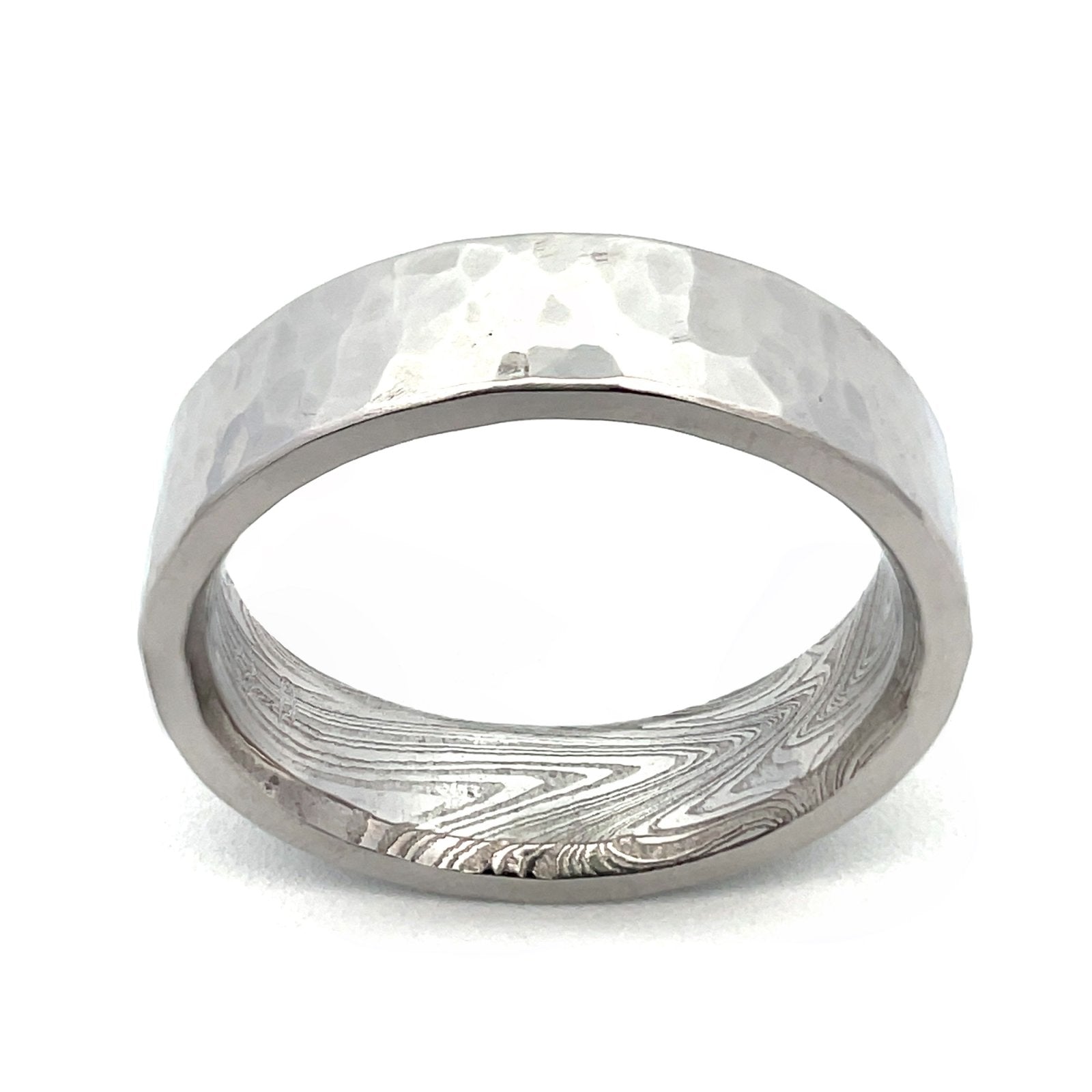 Silver ring with a textured, patterned surface on a white background