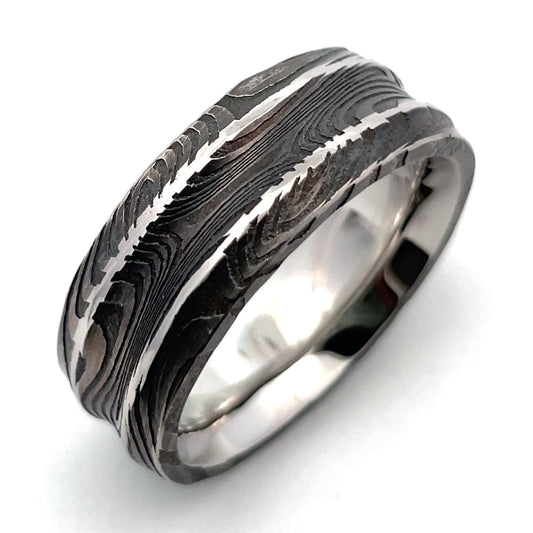 Damascus steel pattern band ring on a white background.