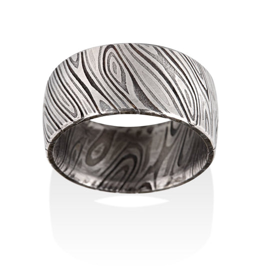 Damascus steel pattern band ring on a white background.