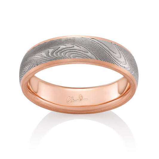 Rose gold ring with a Damascus steel pattern on a white background.