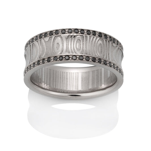 Silver ring with a Damascus steel pattern and black diamond accents on a white background