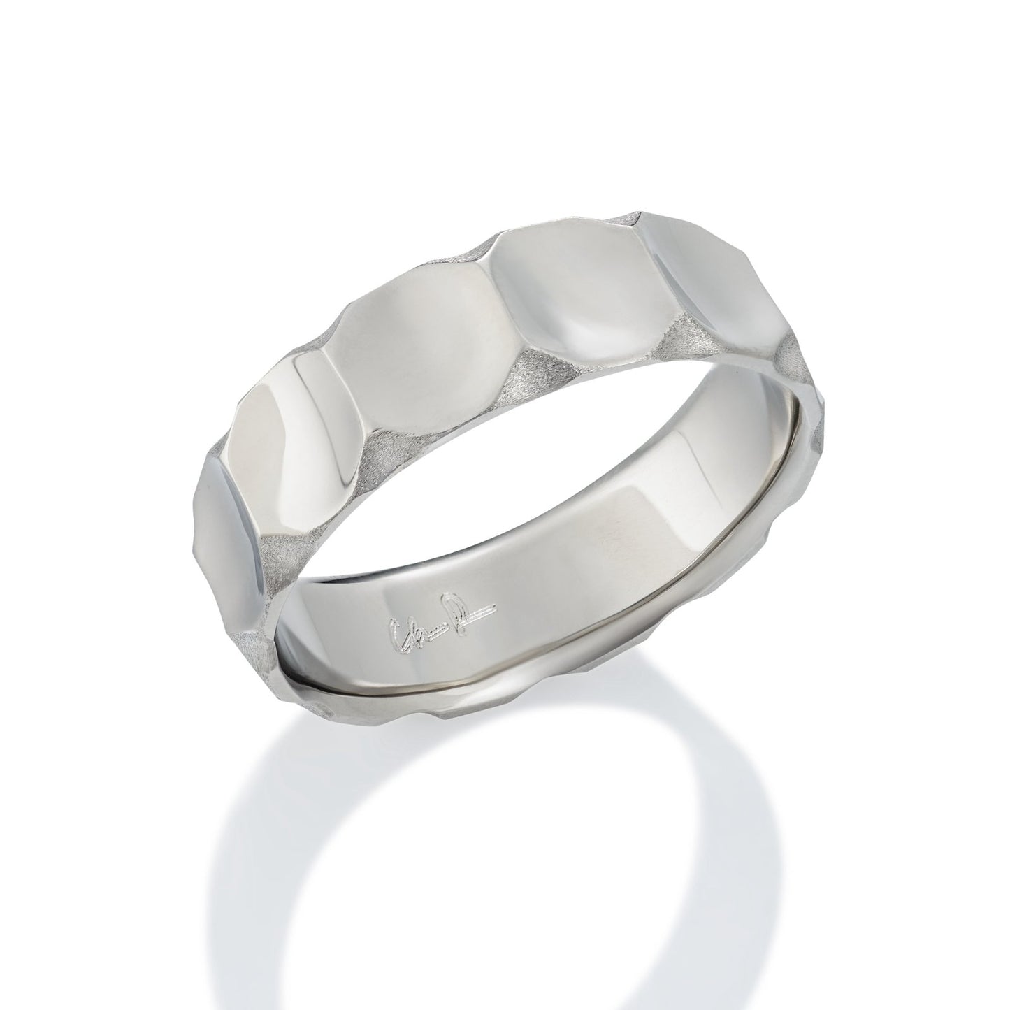 Silver ring with a textured, geometric pattern on a white background.