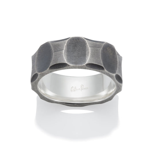 Silver ring with a textured, geometric pattern on a white background