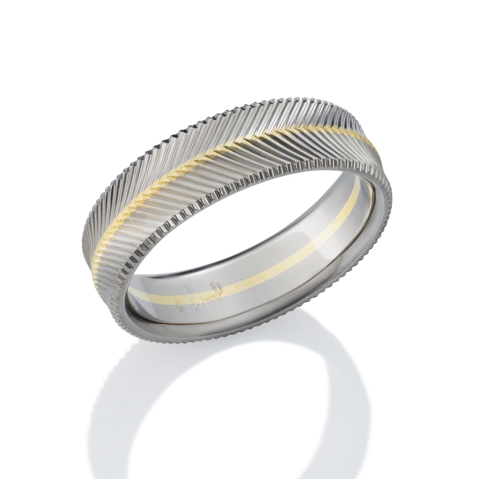 Two-tone wedding band with a textured, chevron pattern and a yellow gold inlay on a white background