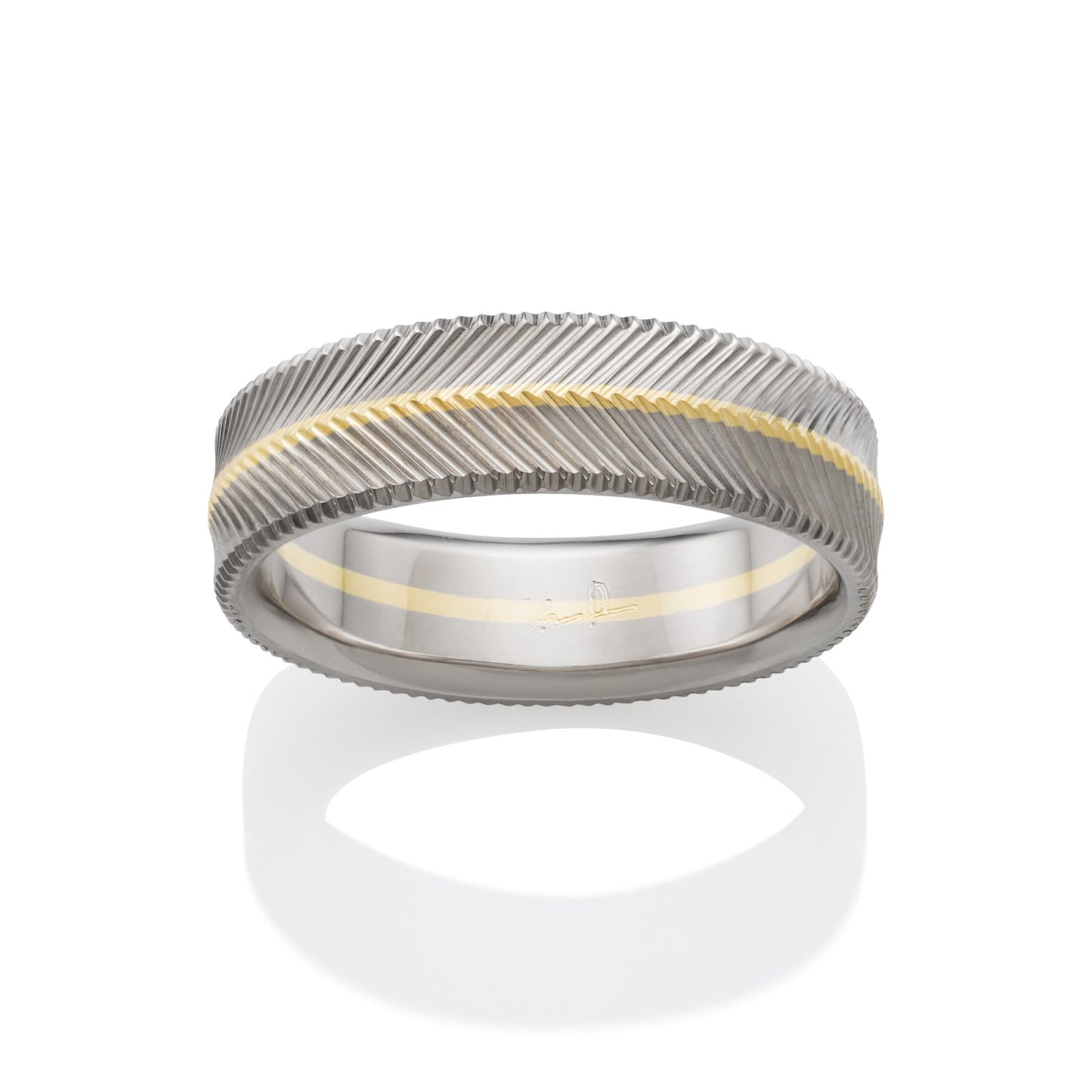 Two-tone wedding band with a textured, chevron pattern and a yellow gold inlay on a white background