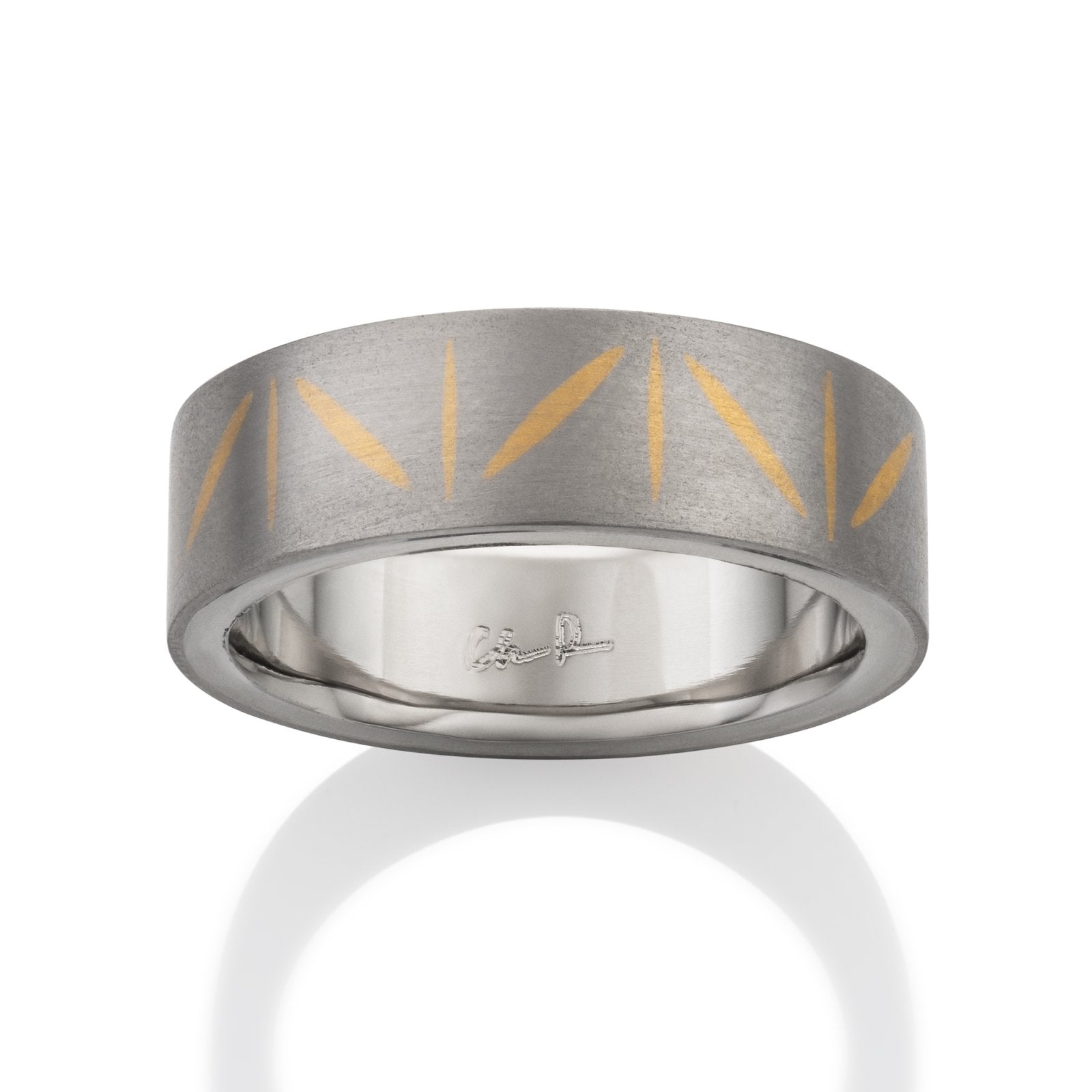 Two-tone tiatanium wedding band with a  yellow gold inlay on a white background