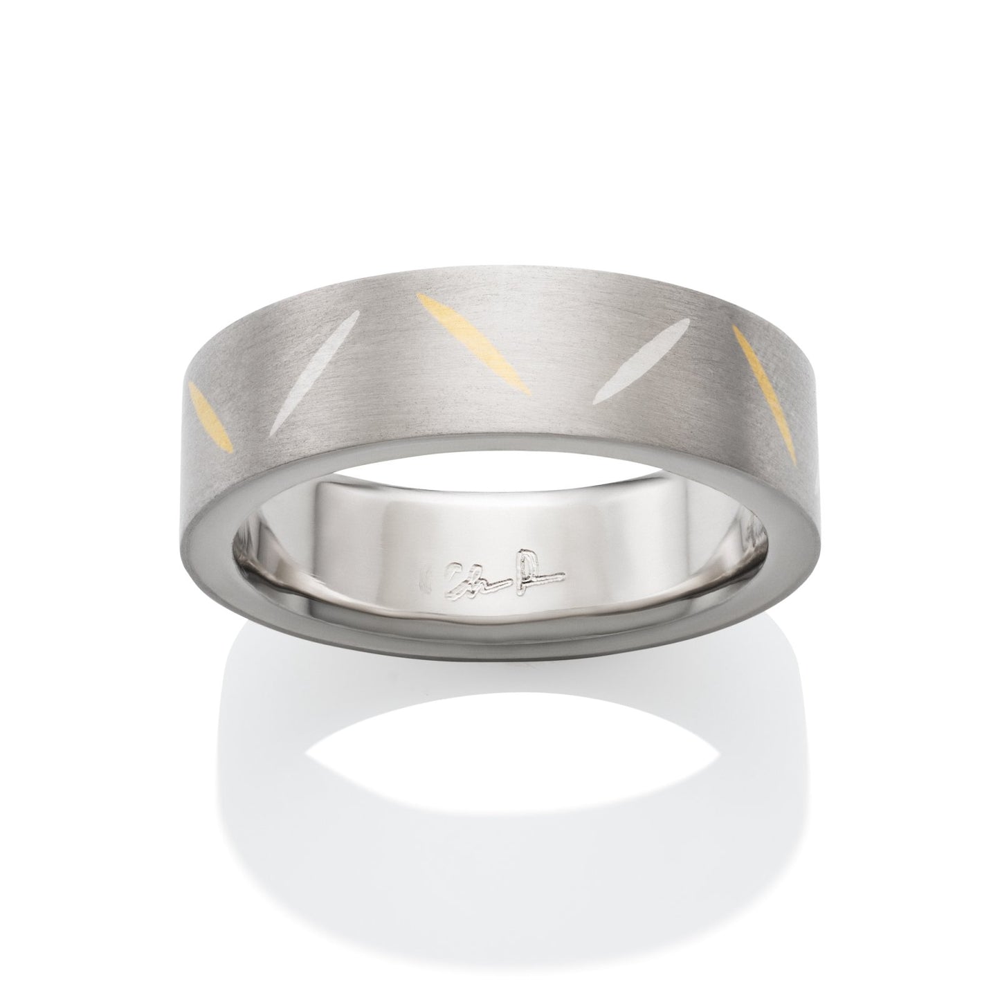 Two-tone tiatanium wedding band with a  yellow gold inlay on a white background