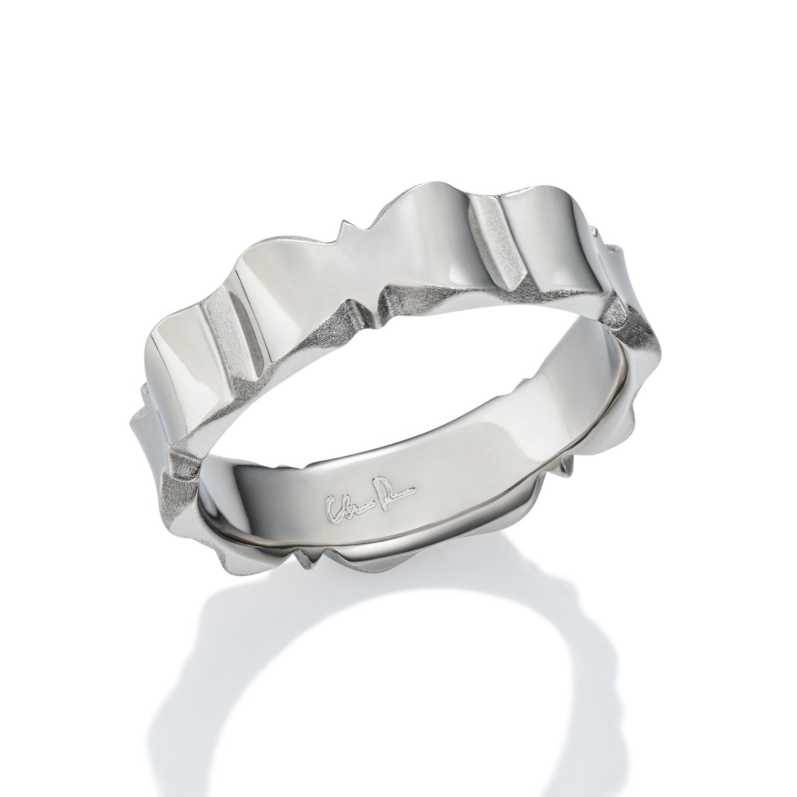 Silver ring with a wave-like design on a white background