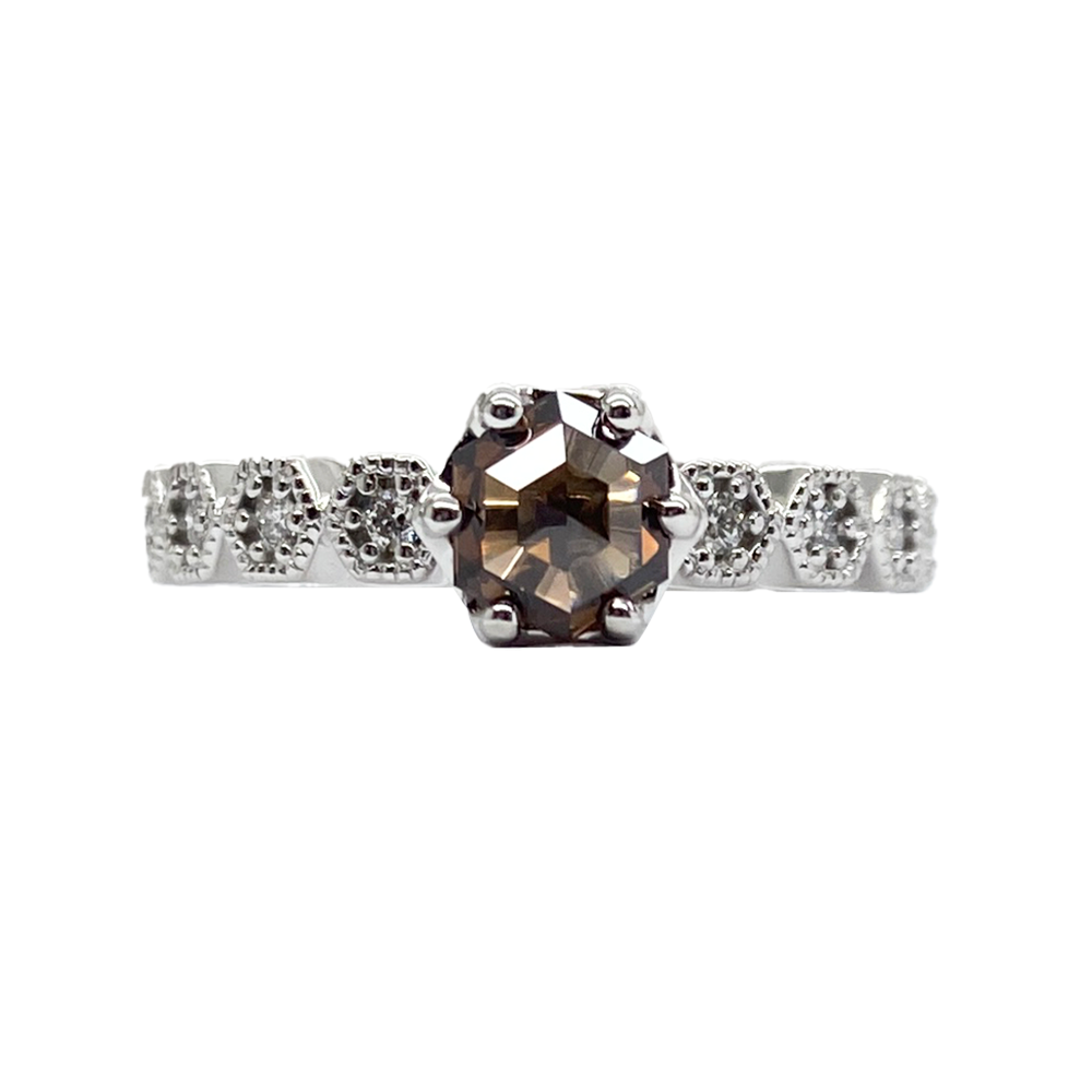 Silver ring with a large, octagonal brown gemstone in a four-prong setting, surrounded by smaller diamonds in a geometric design.