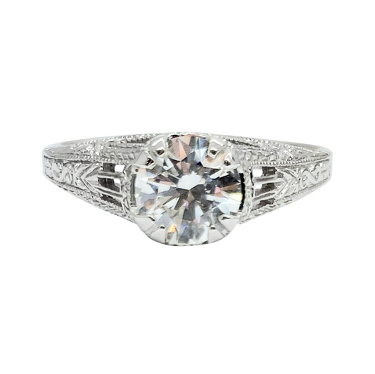 Silver diamond engagement ring with a large center stone and intricate filigree detailing on the band.