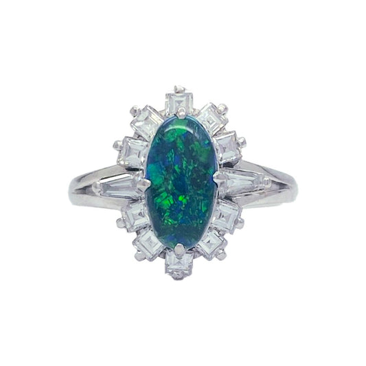 Silver ring with a large, oval-shaped black opal center stone surrounded by a halo of smaller, round diamonds.