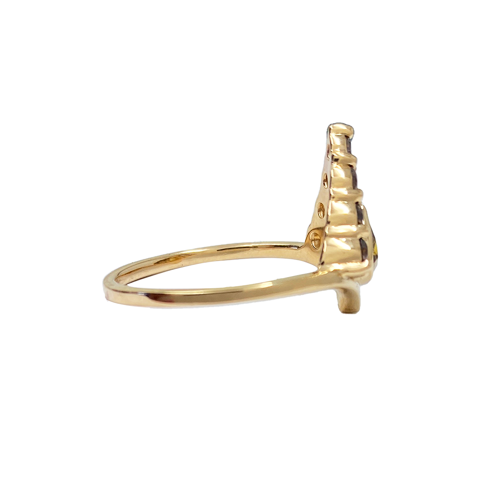 Side view of gold ring with a pear-shaped green gemstone surrounded by smaller diamonds in a prong setting.